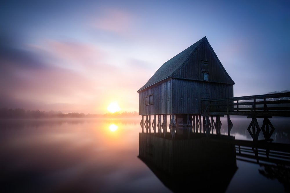 Lever de soleil sur le hangar à bateaux brumeux - Christoph Schaarschmidt