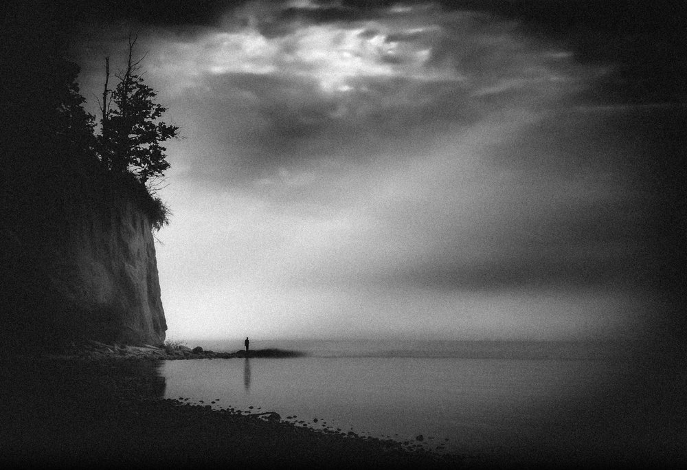 Une silhouette solitaire sur le rivage brumeux - Monika Zemojtel