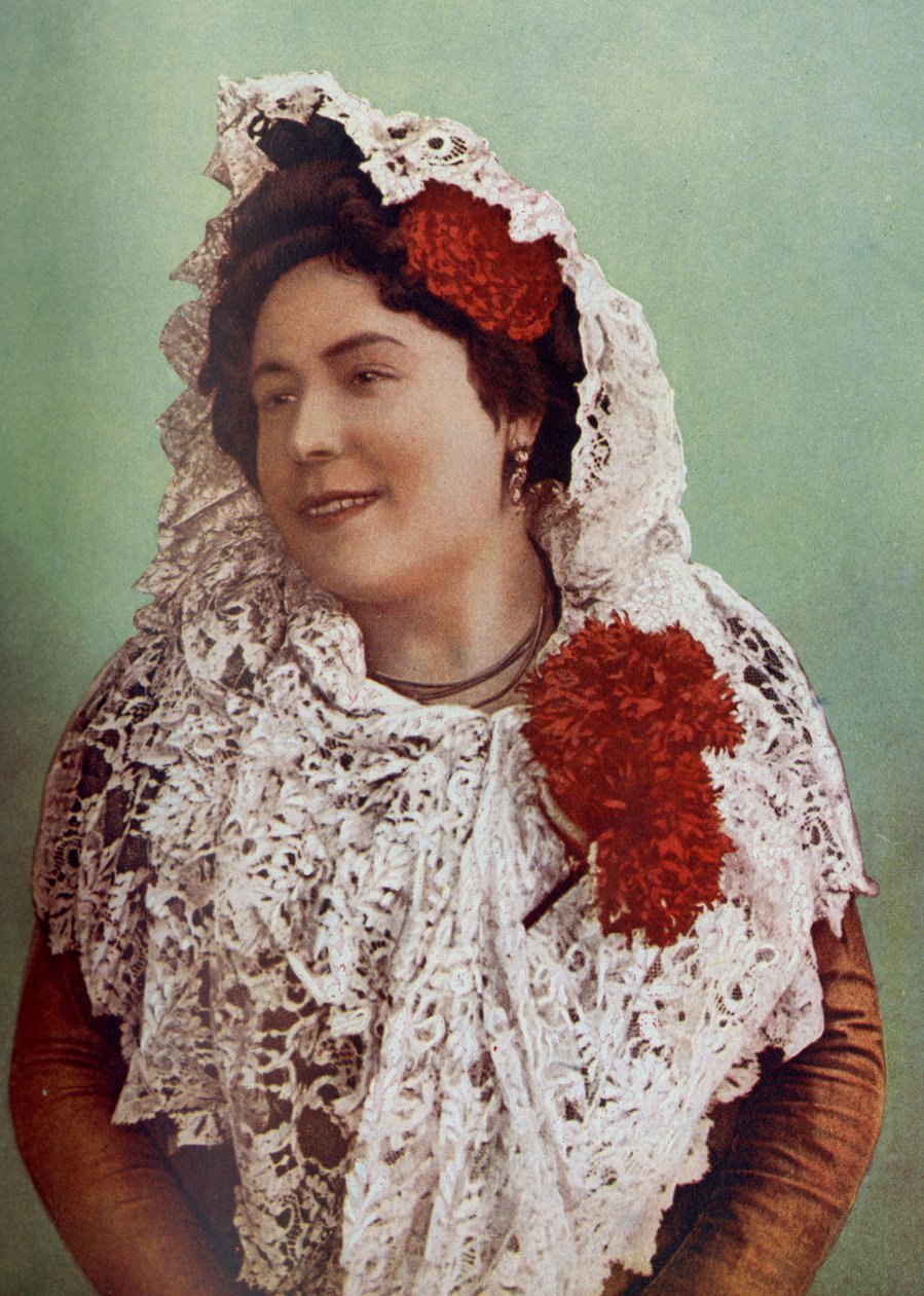 Espagne. Fleurs écarlates et mantille de dentelle blanche drapée sur les cheveux et les épaules mettent en valeur la beauté méridionale de l