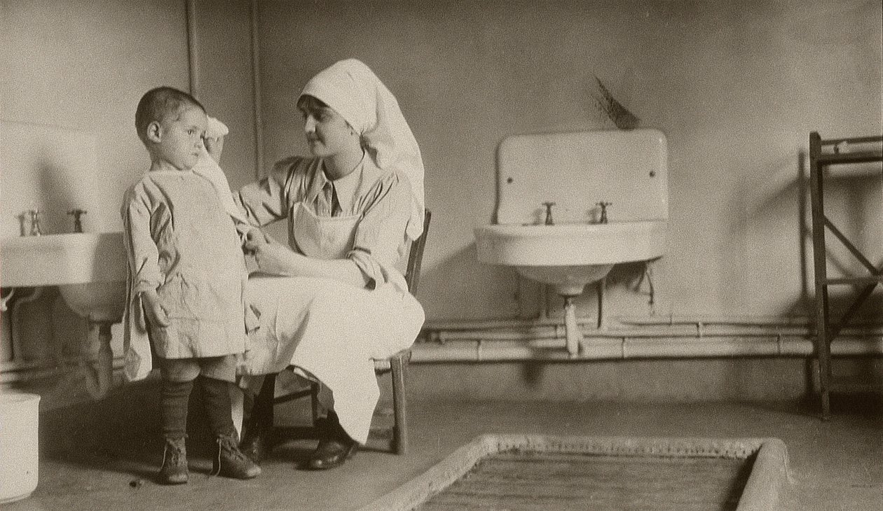 Infirmière soignant un enfant malade aux colonies de Passay et Saint-Quentin pour réfugiés et orphelins - American Photographer