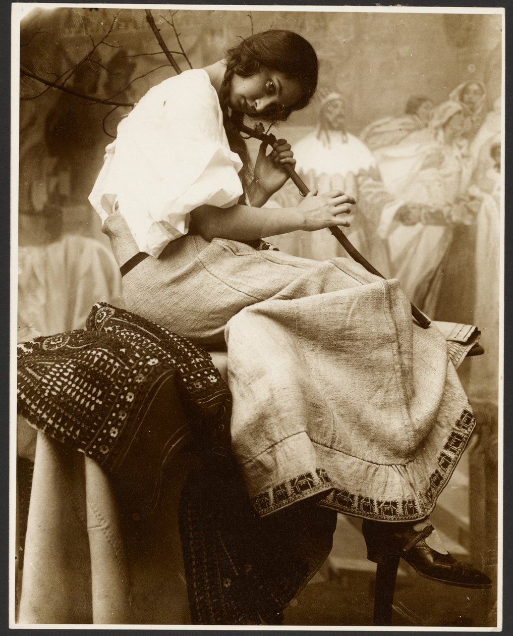 [Modèle féminin assis tenant une branche d