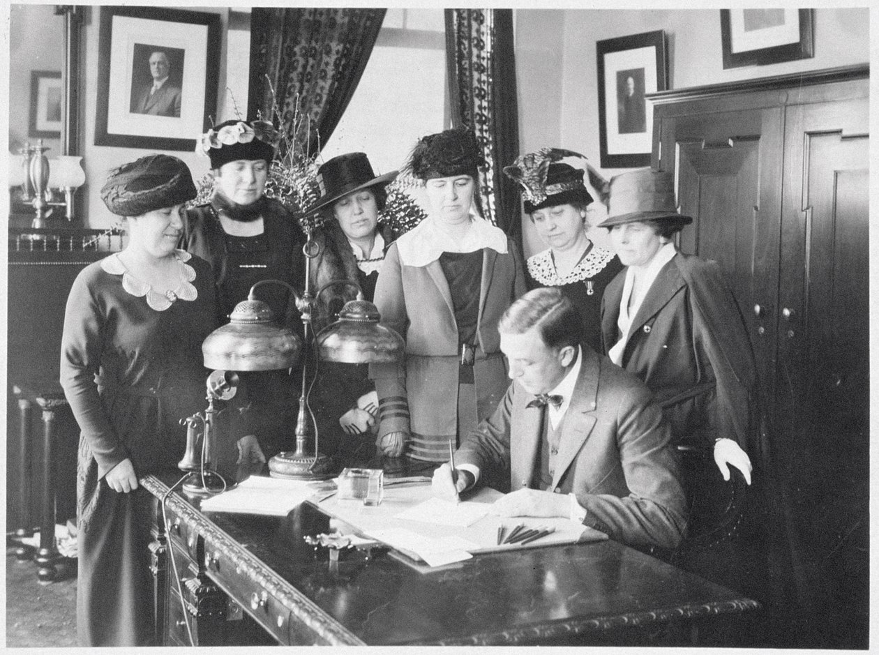 Le gouverneur Carl Elias Milliken signant le projet de loi sur le suffrage sous le regard de six femmes, 1917 - American Photographer