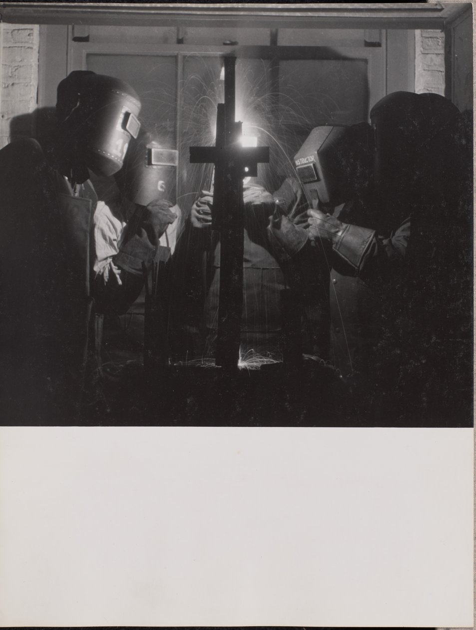 [Quatre hommes portant des casques de soudure soudent une pièce de métal]. - Arnold Eagle