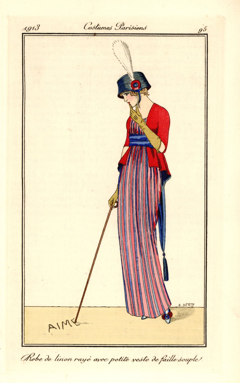 Femme en robe de lin rayée et gilet en soie côtelée souple, chapeau avec cocarde. Elle écrit amour avec sa canne dans le sable - B Berty