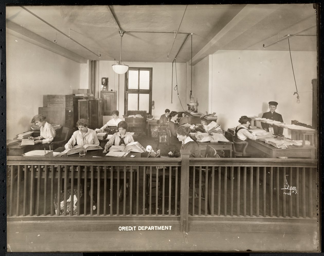 Un homme et une femme travaillant dans le bureau de crédit de la Mantle Lamp Co. of America, New York, 1915-16 - Byron Company