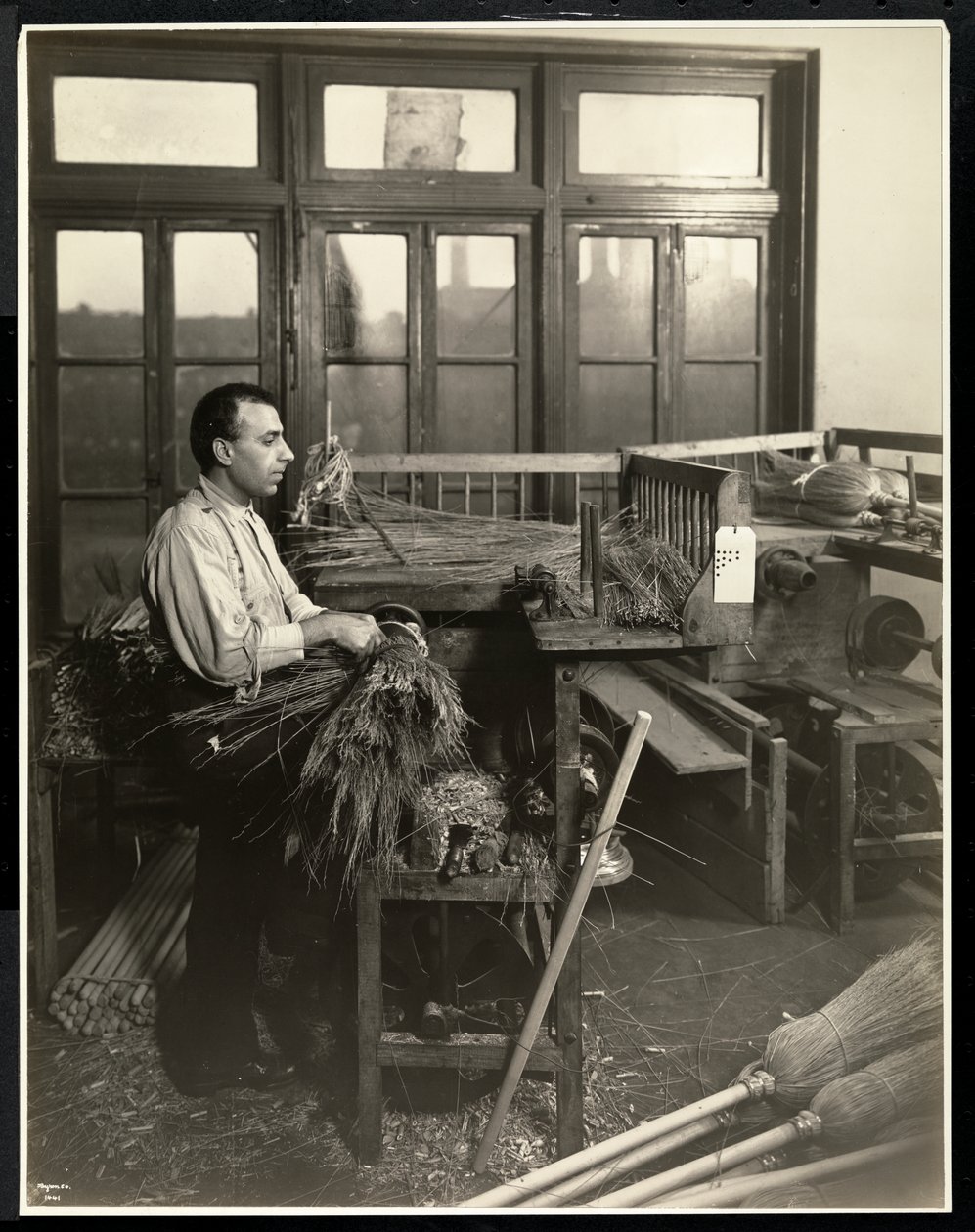 Aveugle attachant de la paille sur des manches de balai au Bourne Memorial Building, New York, 1921 - Byron Company