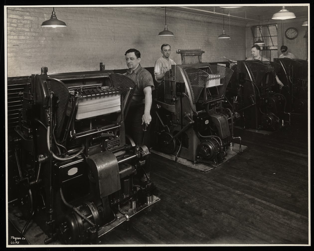 Hommes travaillant sur des presses à imprimer chez Unz und Co., 24 Beaver Street, New York, 1932 - Byron Company