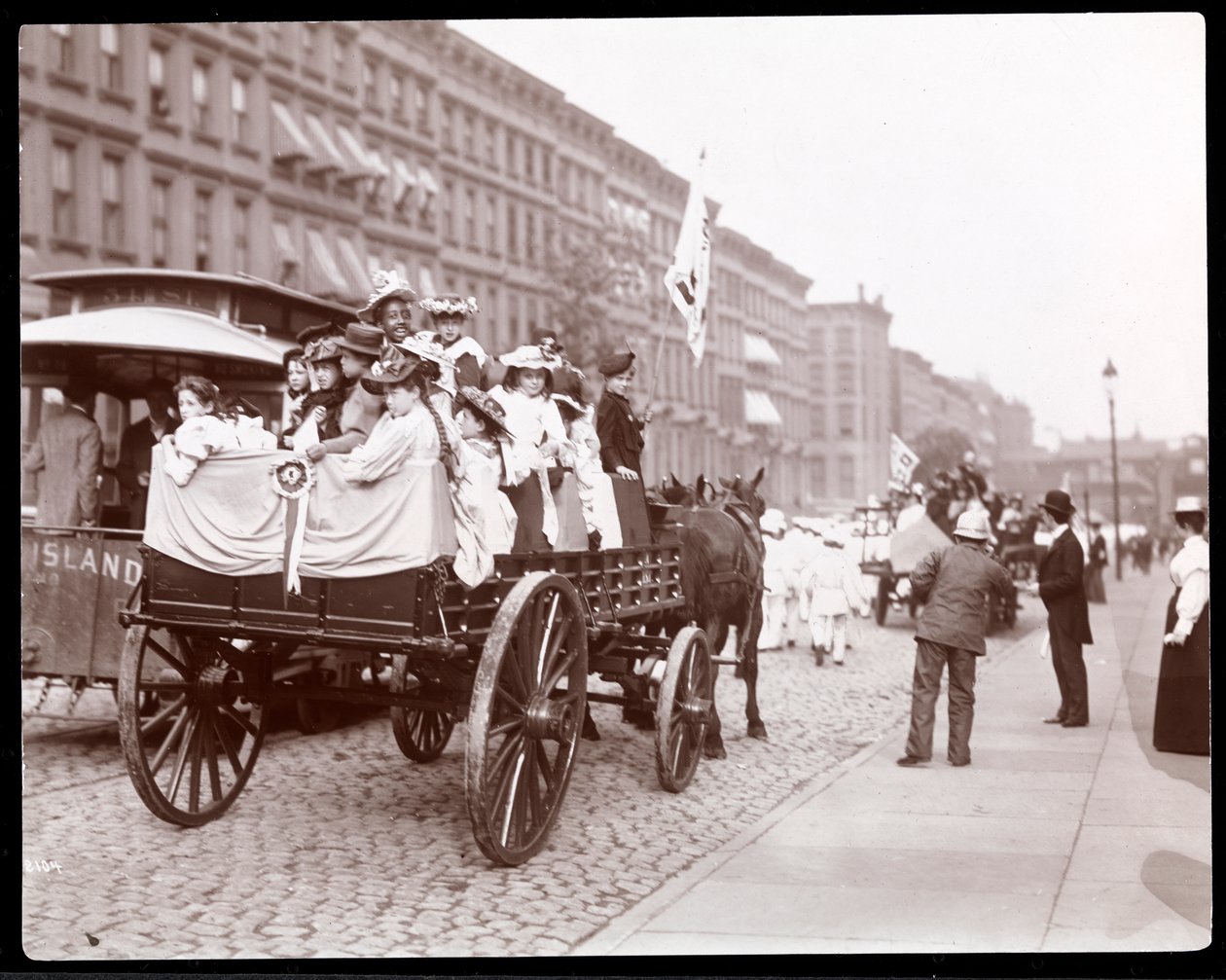 Vue de jeunes femmes dans un char lors du défilé des nettoyeurs de rue sur la 34e rue près de la 4e avenue, New York, 1896 - Byron Company