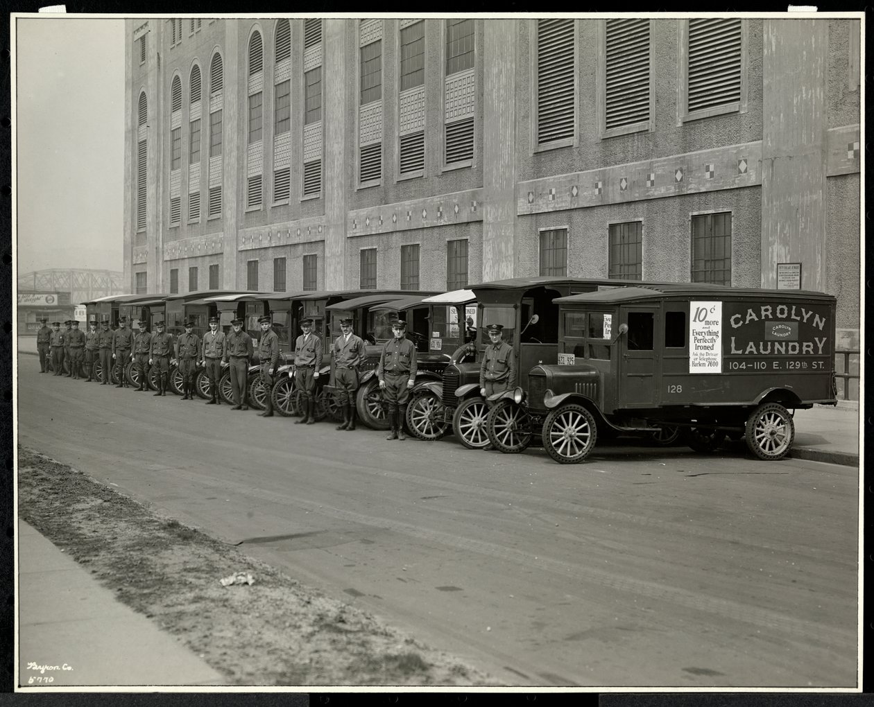 Une ligne de camions de livraison garés devant la blanchisserie Carolyn au 111 East 128th Street, East Harlem, New York, 1929 - Byron Company