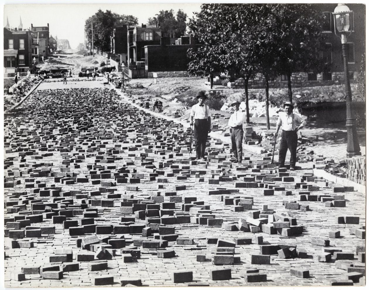 Trois hommes travaillant à paver une rue avec des briques, Compton près de Meramec - Charles Clement Holt