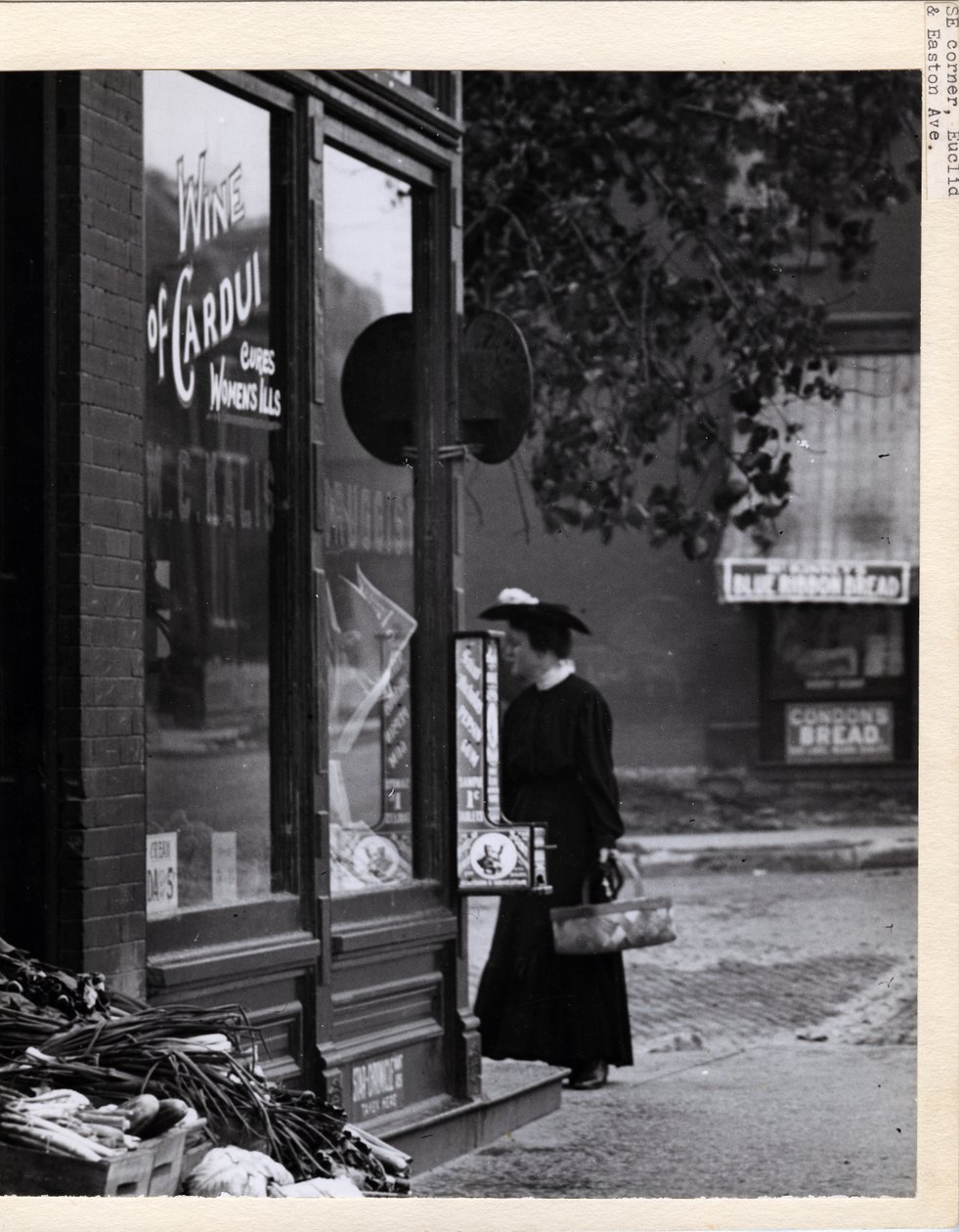 Photographie verticale en noir et blanc montrant une femme tenant un panier devant l