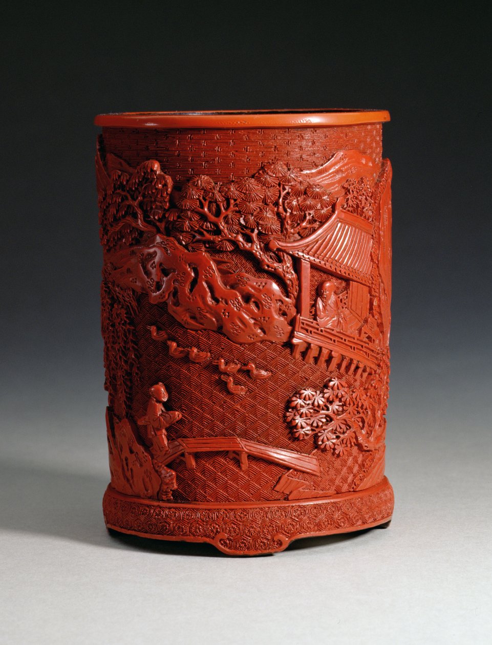 Pot à pinceaux rouge moulé, représentant le célèbre calligraphe Wang Hsi-chih (c.307-365 AD) assis dans son pavillon, regardant des oies dans un étang et un garçon traversant un pont, dynastie Ching, période Qianlong - Chinese School