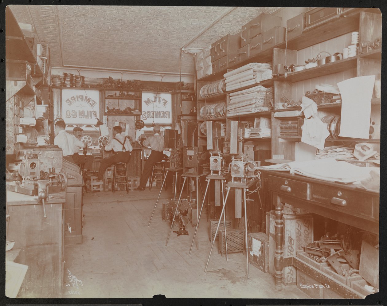 Laboratoire de films Empire Film Co. (possiblement à Broadway et 55e Rue) avec des hommes travaillant et des bobines de film et des caméras - Company Byron