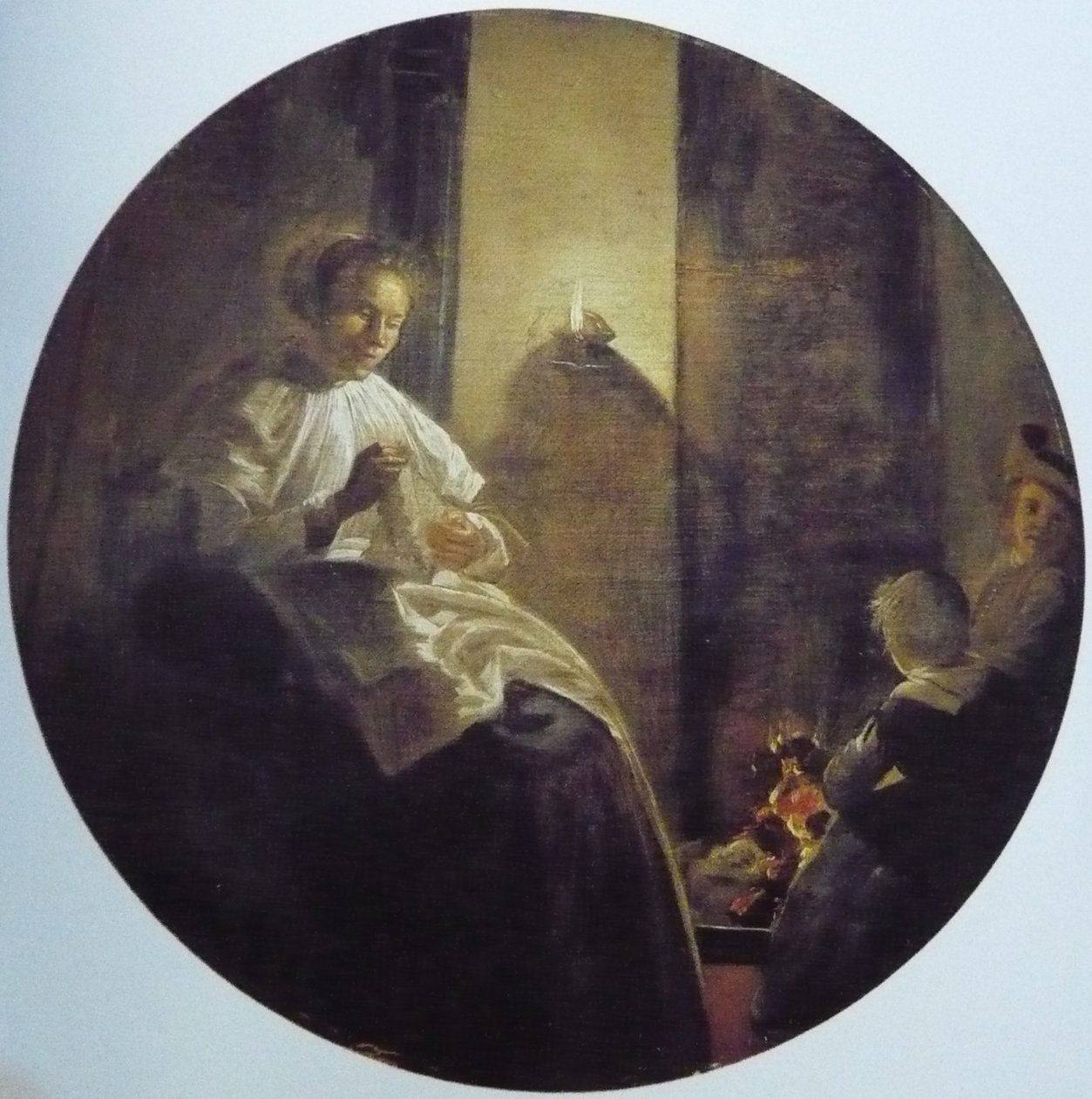 Une femme cousant à la lueur d