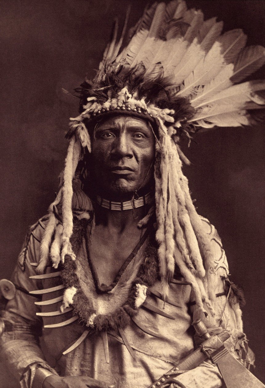 Queue de Belette (Apohsuyis). Cet Indien Piegan porte la célèbre coiffe de guerre en plumes d