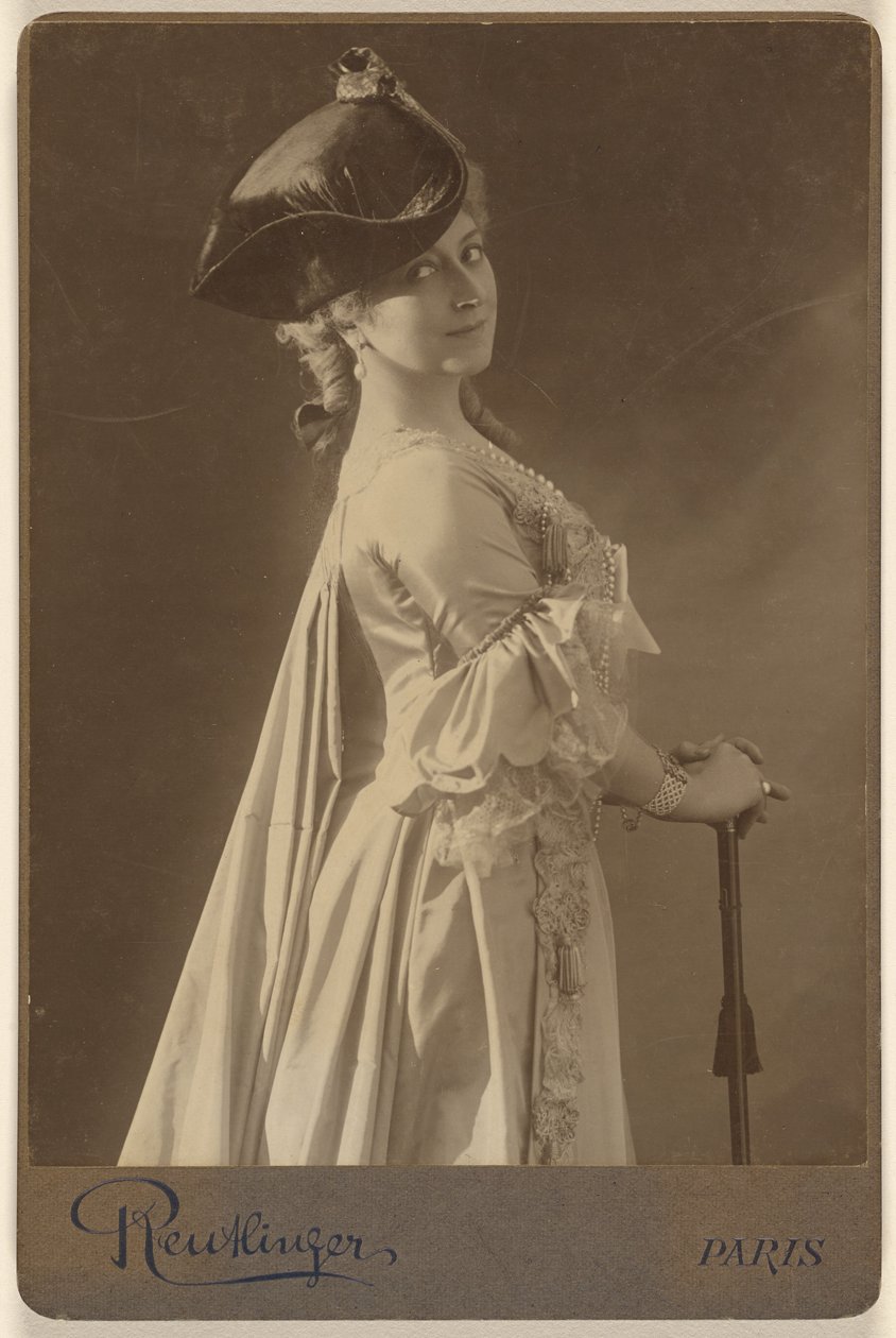 [Femme non identifiée portant un chapeau noir, debout, les mains posées sur une canne]. - Emile Auguste Reutlinger