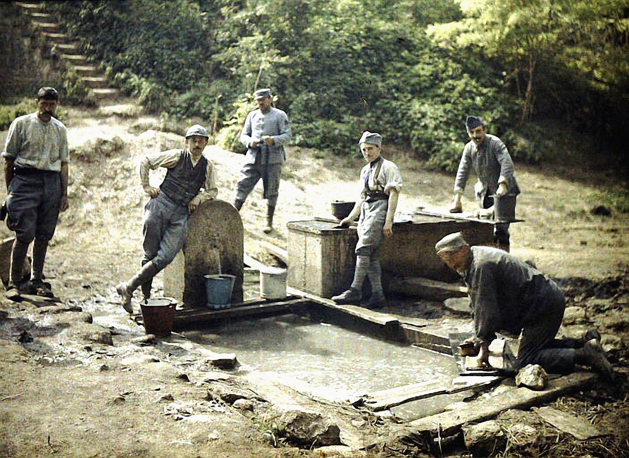 Six soldats français avec des seaux et du linge à une fontaine, Soissons, Aisne, France, 1917 (autochrome) - Fernand Cuville