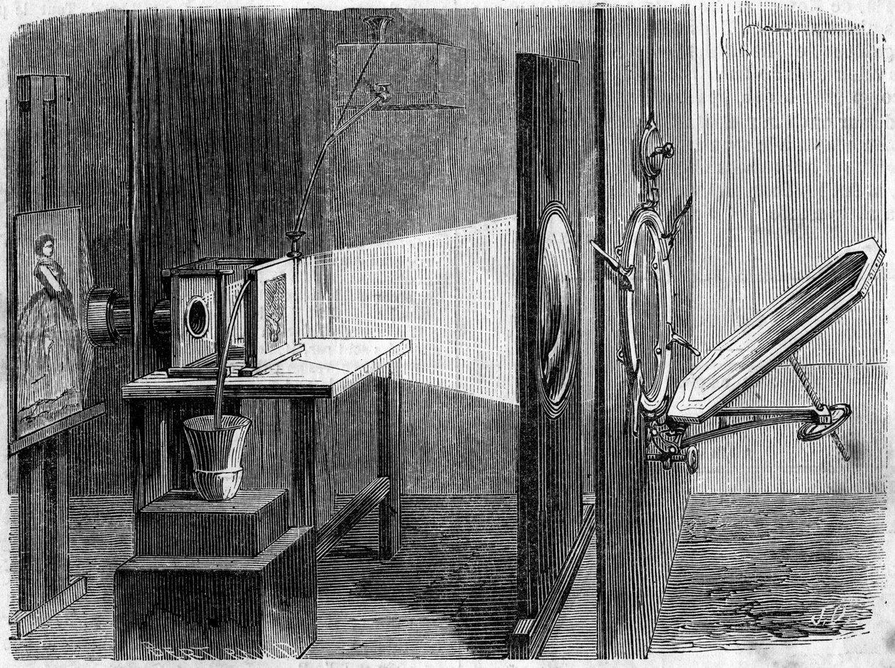 Porte-lumière appliqué à la photographie inventé par Édouard Delessert (1828-1898). Le miroir reflète les rayons du soleil et les renvoie à une lentille qui les réunit en un faisceau pour les faire converger sur un cliché dont l