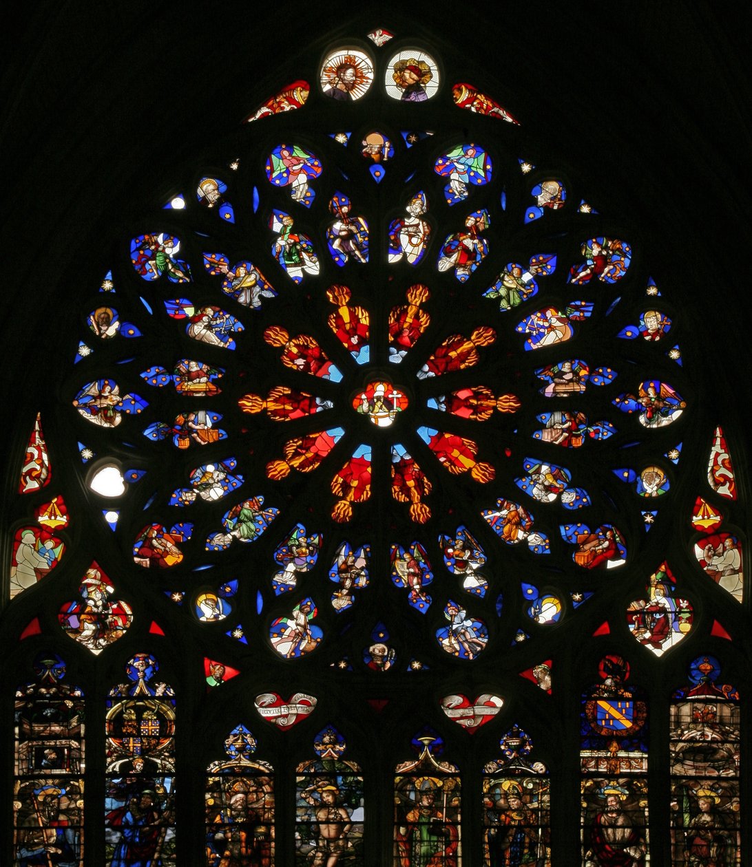 Fenêtre w135 représentant Dieu, séraphins, anges musiciens et dix des Apôtres. Les lancettes en dessous contiennent des figures de la fin du XVIe siècle, les saints patrons des chanoines de l