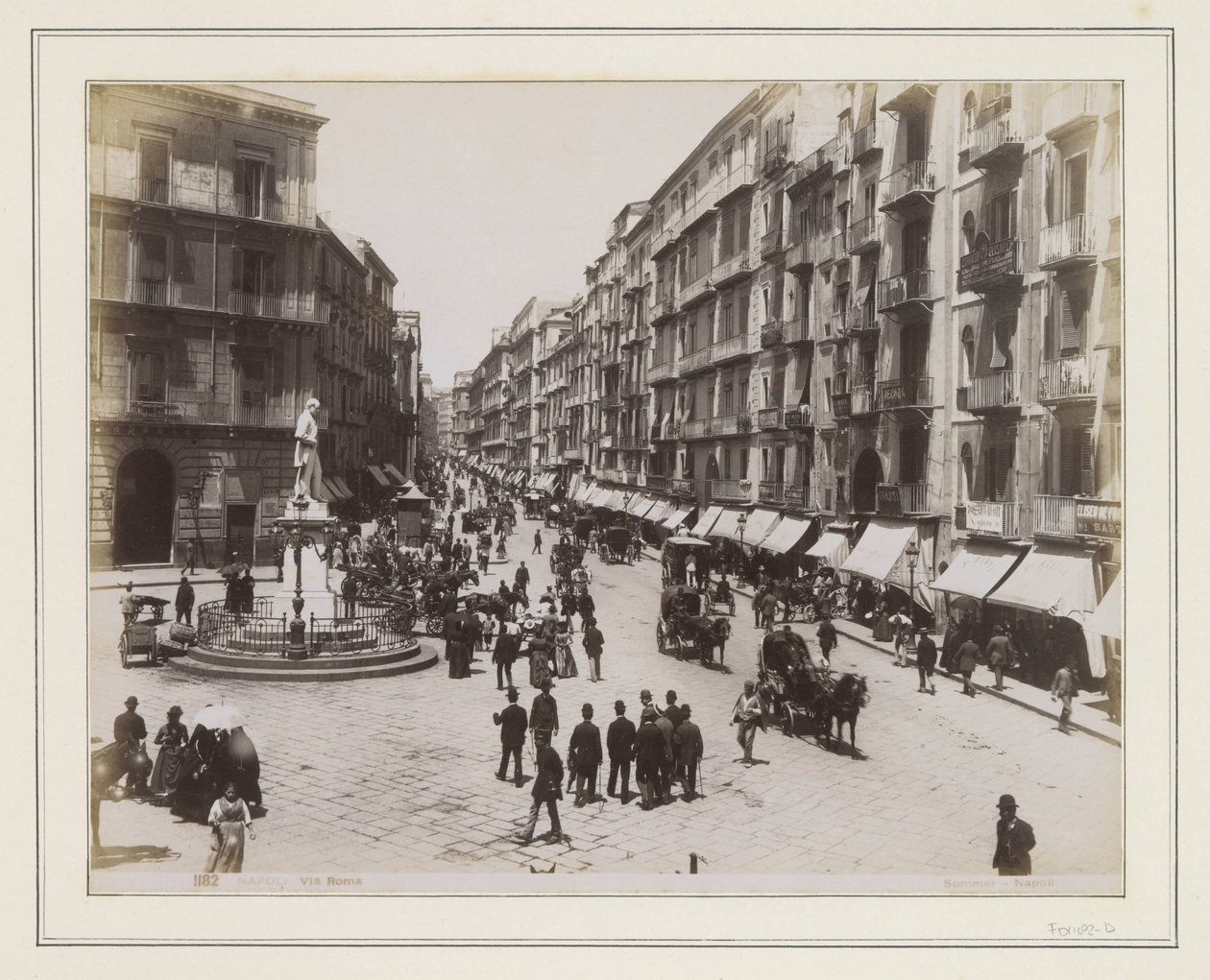 Vue de la Via Roma à Naples, avec une statue, des magasins, des calèches et des passants - Giorgio Sommer