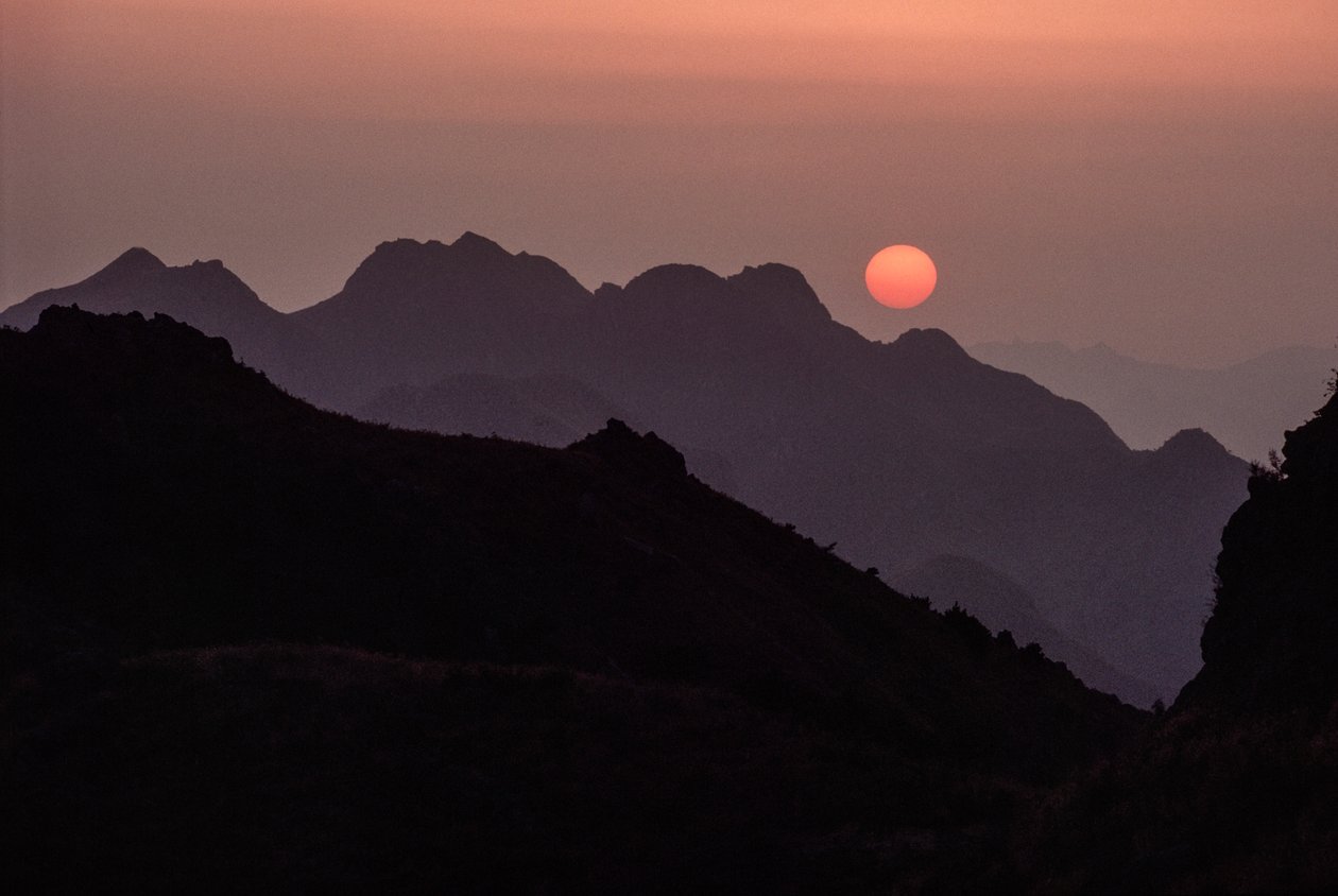 Un soleil cramoisi brillant se couche sur la chaîne de Yan Shan. Shanhaiguan Pass, H... - James L Stanfield
