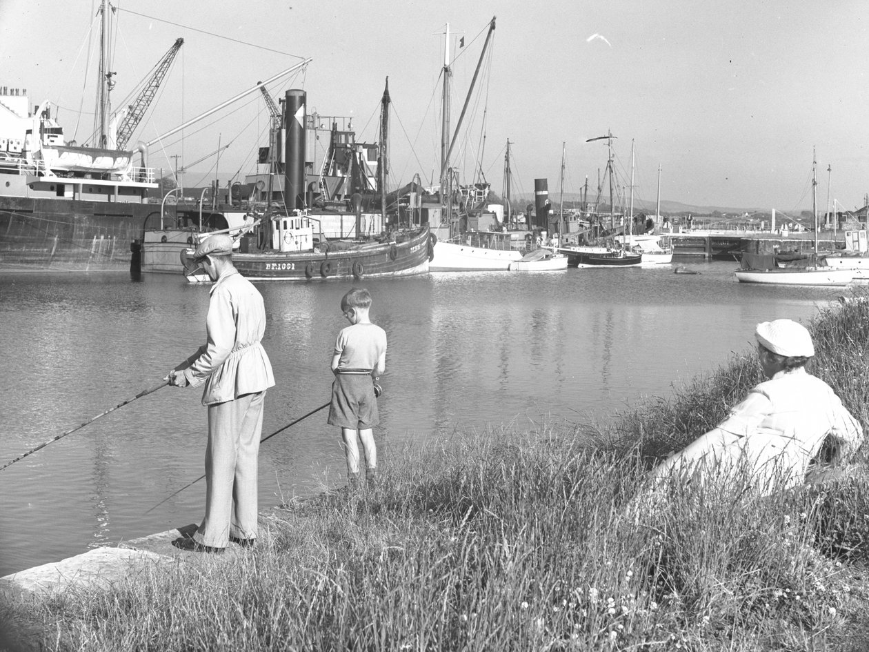 Un homme et un garçon pêchant dans Glasson Dock alors qu