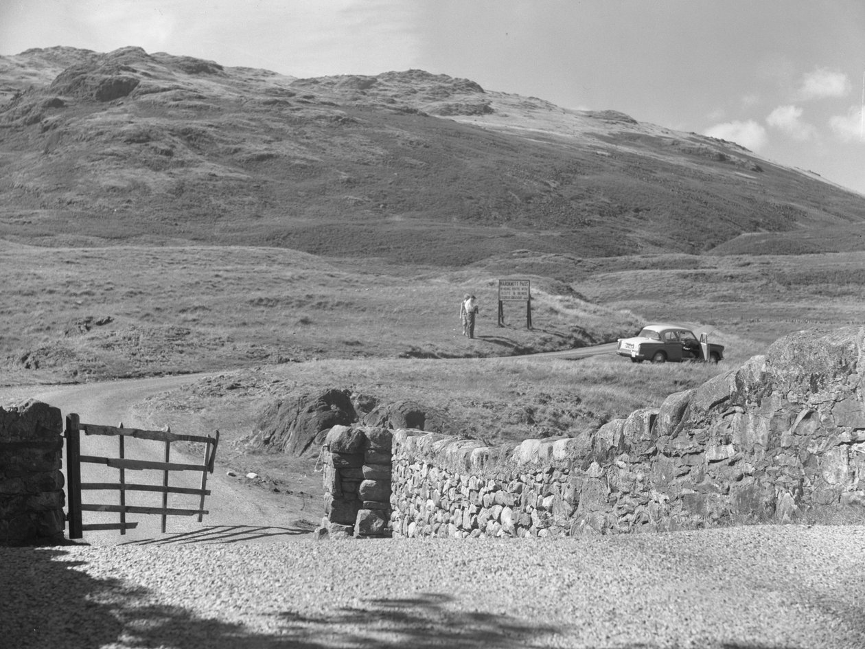 Vue de la route passant par le col de Hard Knott, deux personnes debout près d