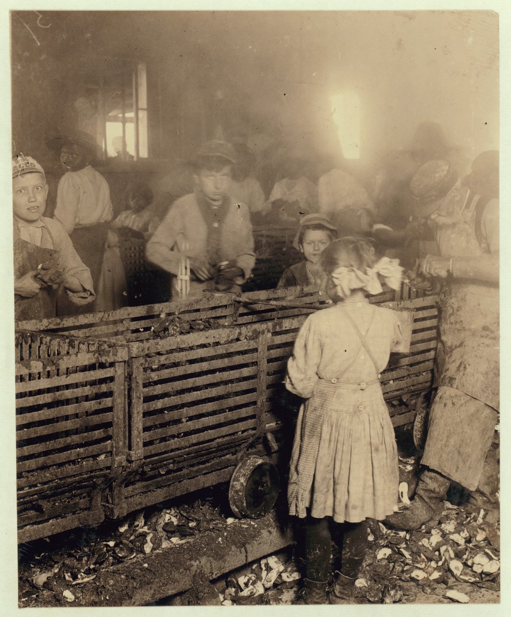 Usine de la Lowden Canning Company, Bluffton, Caroline du Sud montrant une fille de 7 ans qui écale 3 pots d