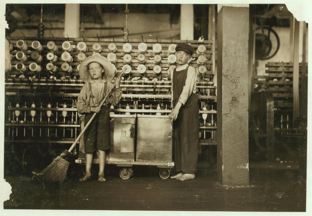 Ronald Webb, 12 ans, et Frank Robinson, 7 ans, fils du chef de salle des cartes, qui balaie et doffe (débarrasse les bobines pleines) aux Roanoke Cotton Mills, Virginie, 1911 - Lewis Wickes Hine