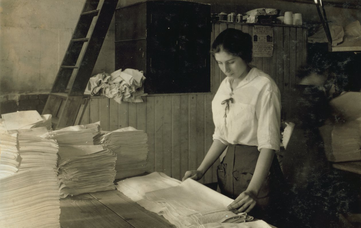 Une jeune fille de 15 ans plie des serviettes dans la blanchisserie Bonanno, Boston, Massachusetts. - Lewis Wickes Hine