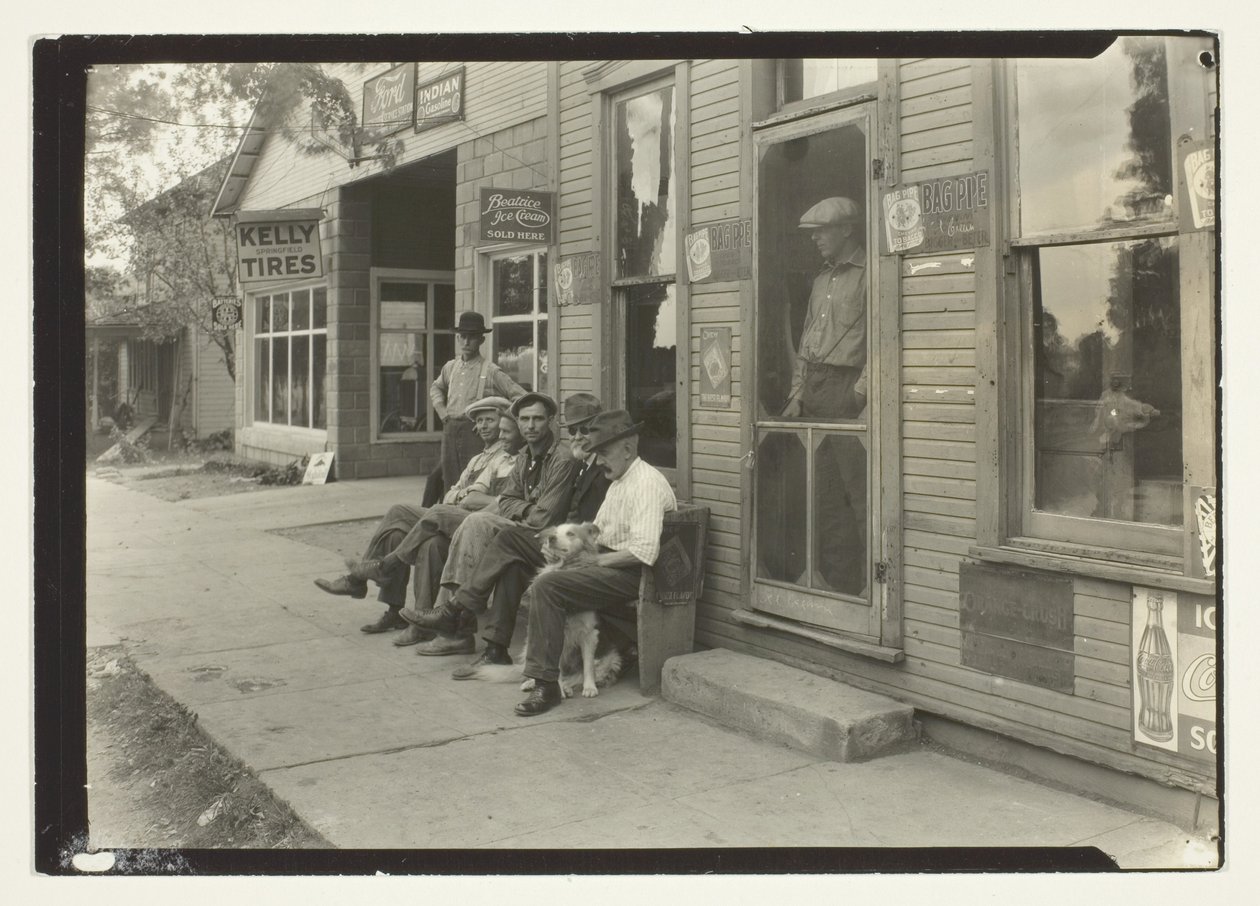 Hommes avec chien assis sur un banc devant un magasin général - Lewis Wickes Hine