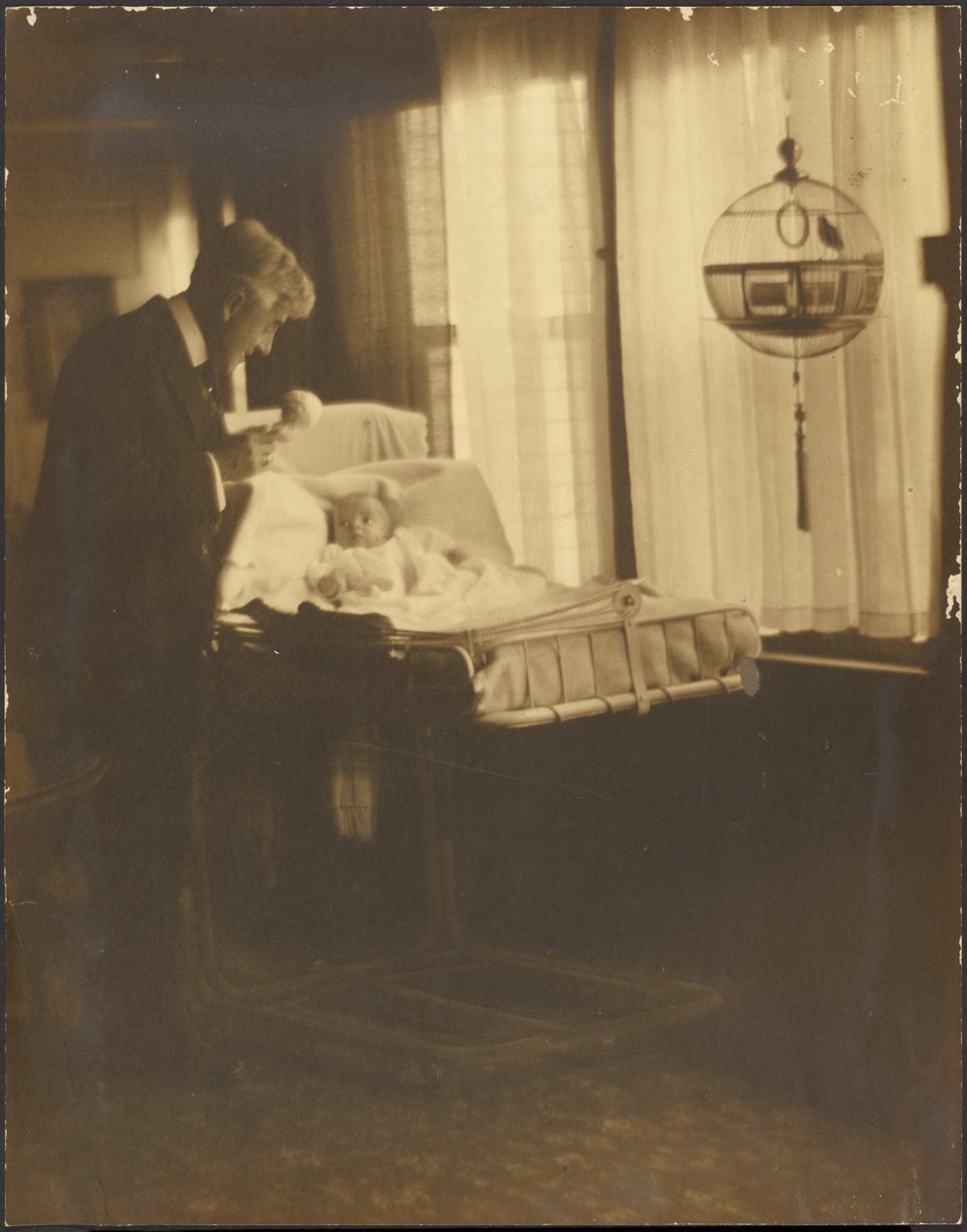 [Un homme et un bébé avec une cage à oiseaux] - Louis Fleckenstein