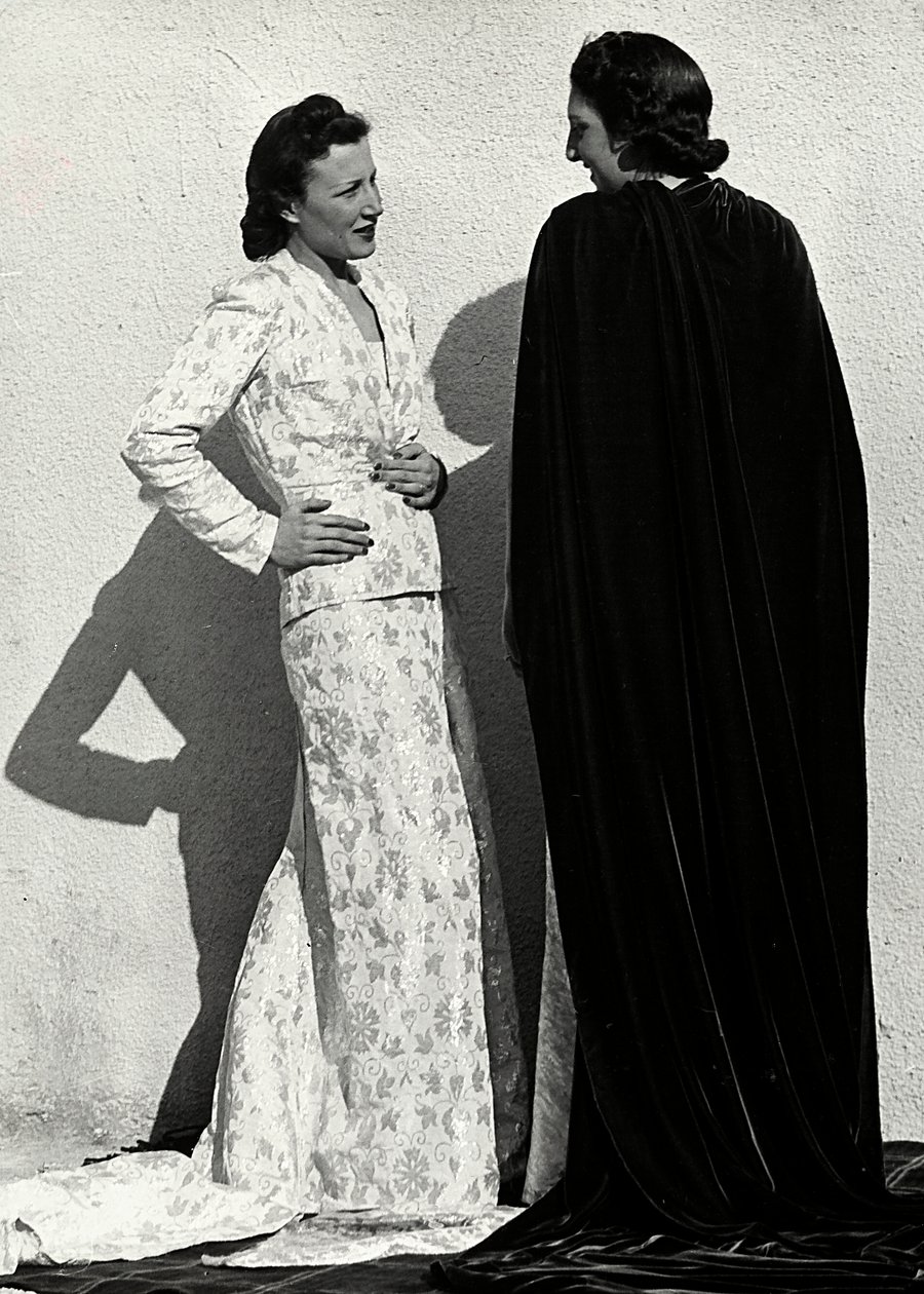 Deux mannequins présentent des créations de la maison de couture italienne "Dragoni". Un mannequin porte une tenue en tissu damassé composée d