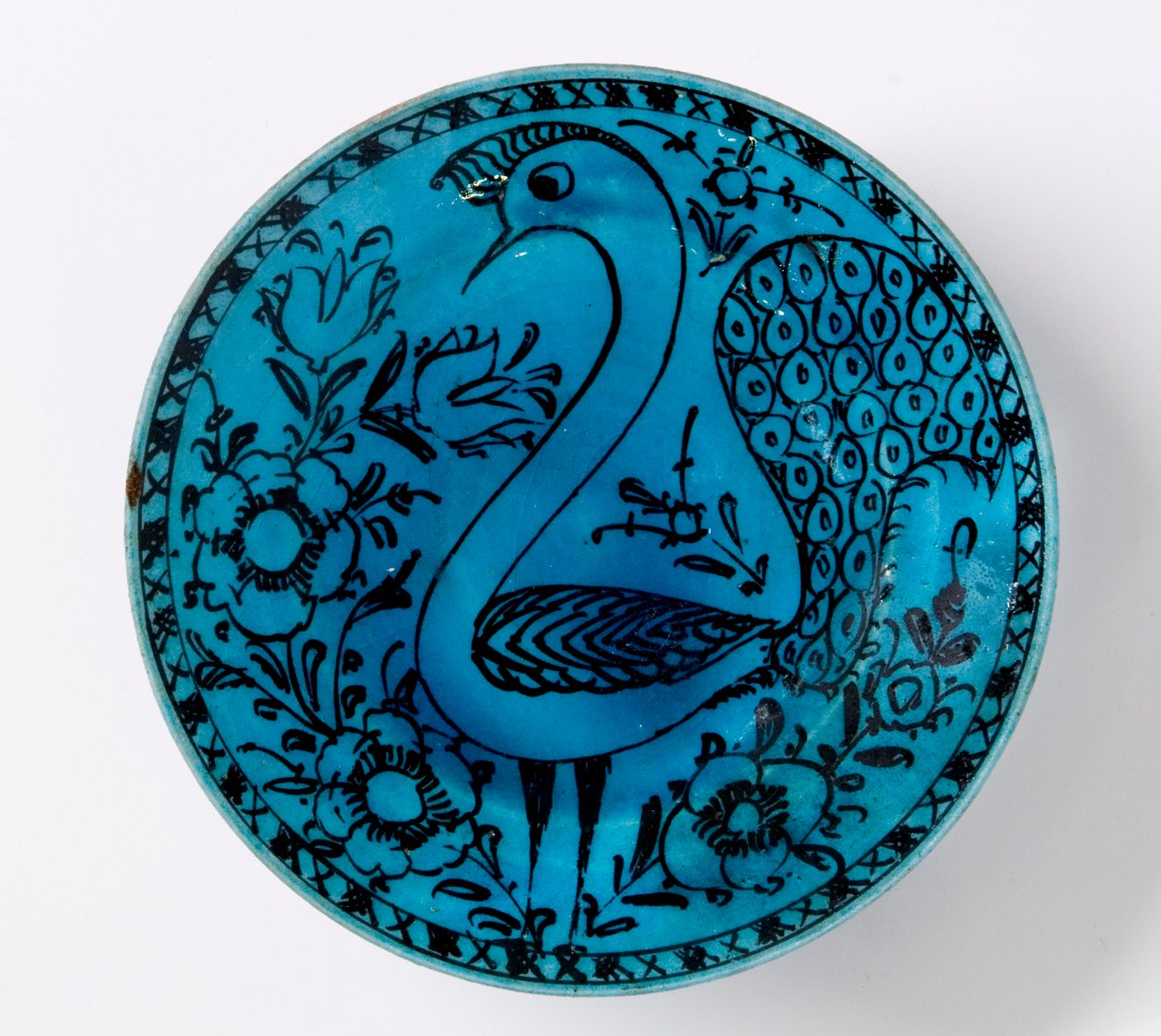 Un plat en poterie persane du 19ème siècle représentant un paon sur un fond turquoise - Persian School