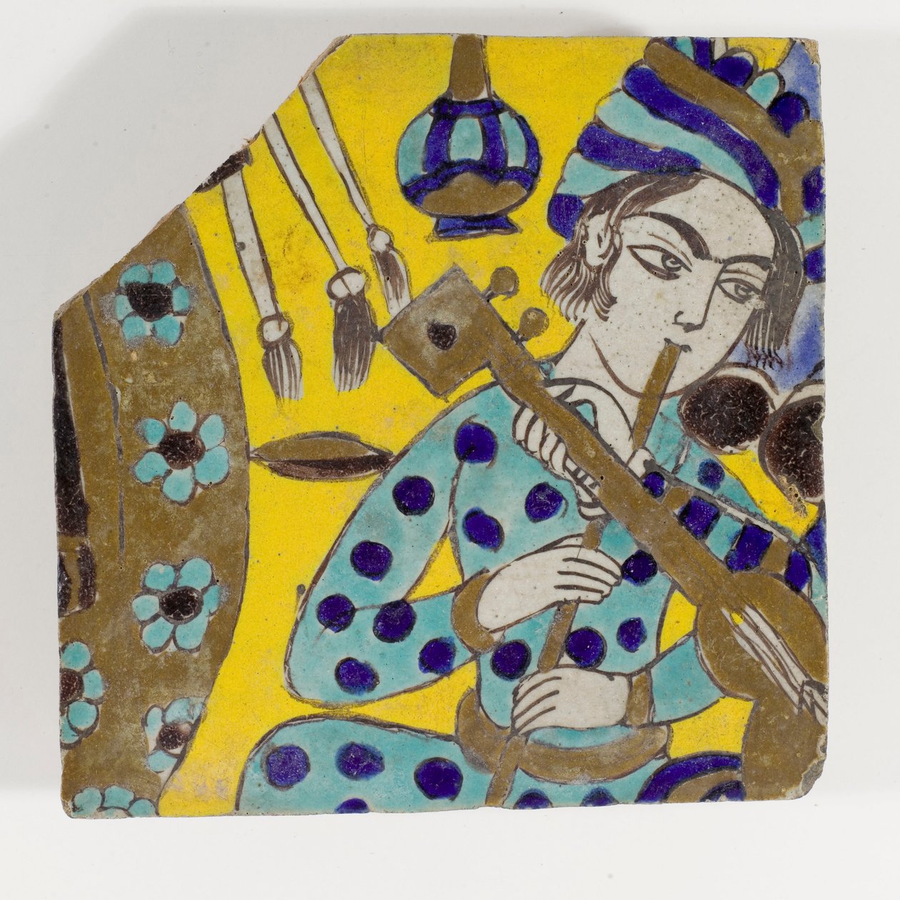 Carreau de poterie Safavide de Perse de la fin du XVIIe siècle représentant un homme jouant de la flûte avec un turban - Persian School