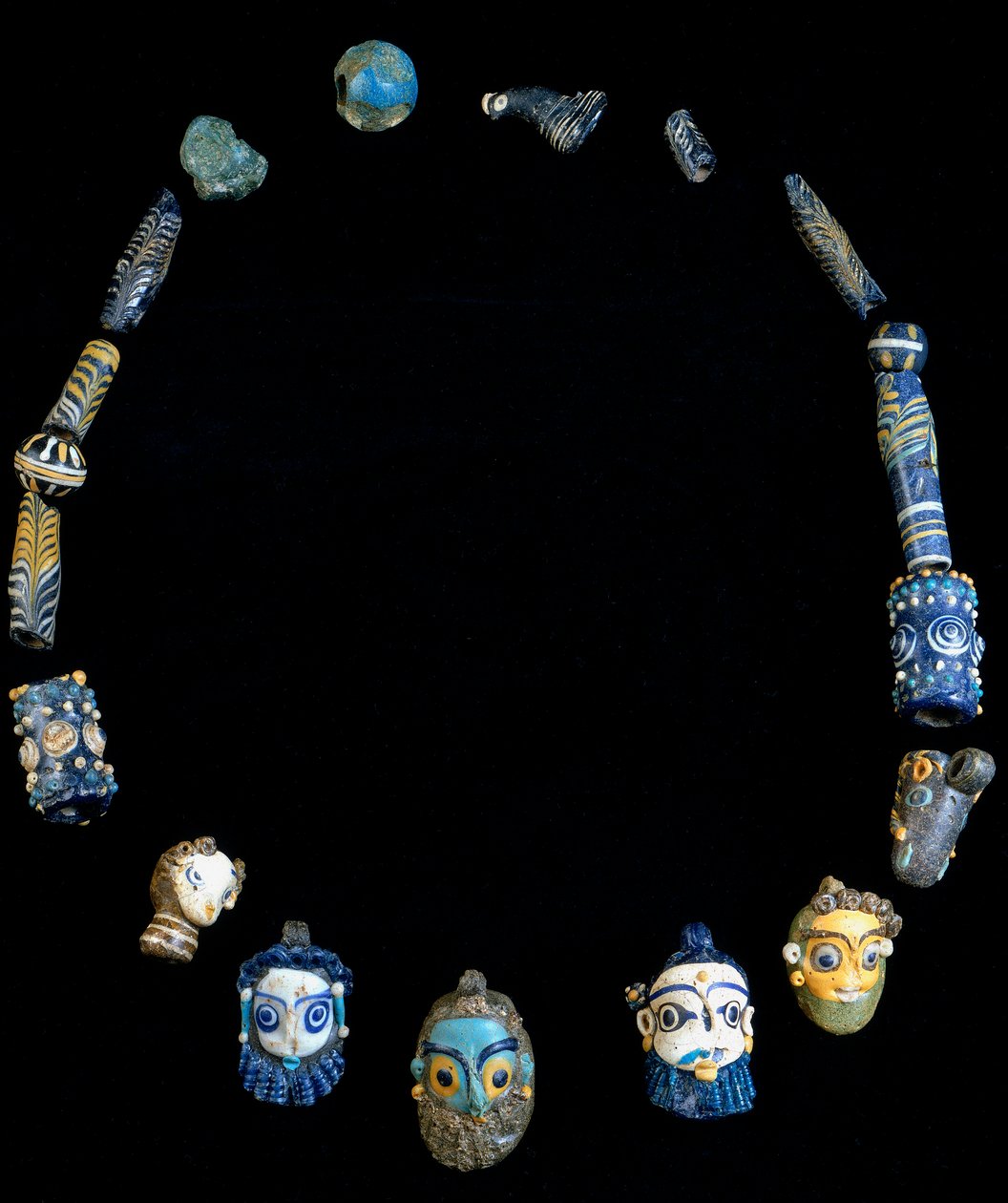 Collier en pâte de verre avec pendentifs représentant des têtes barbus, originaire d