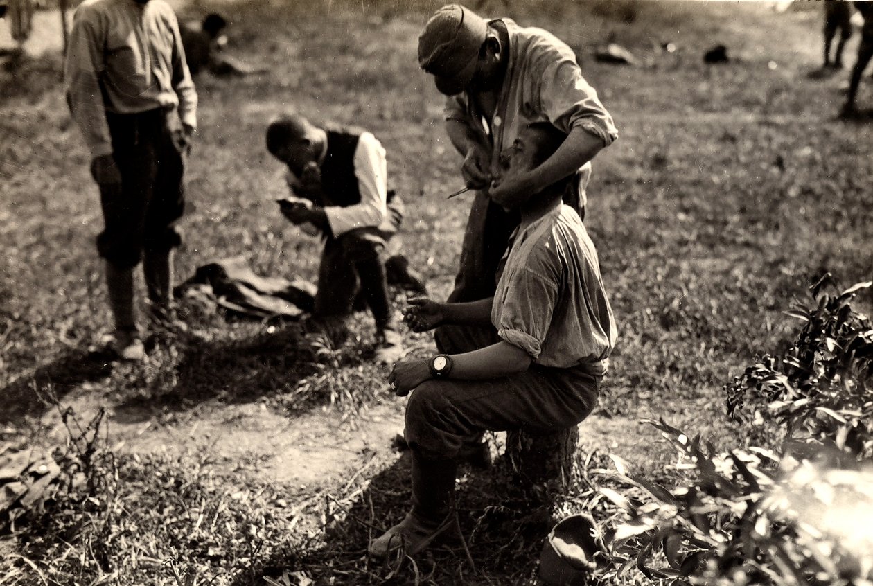 Prisonniers autrichiens pendant la Première Guerre mondiale à Bagnaria Arsa, Udine, Italie; au premier plan, un soldat rase un camarade, 02/04/1916 - Ugo Ojetti