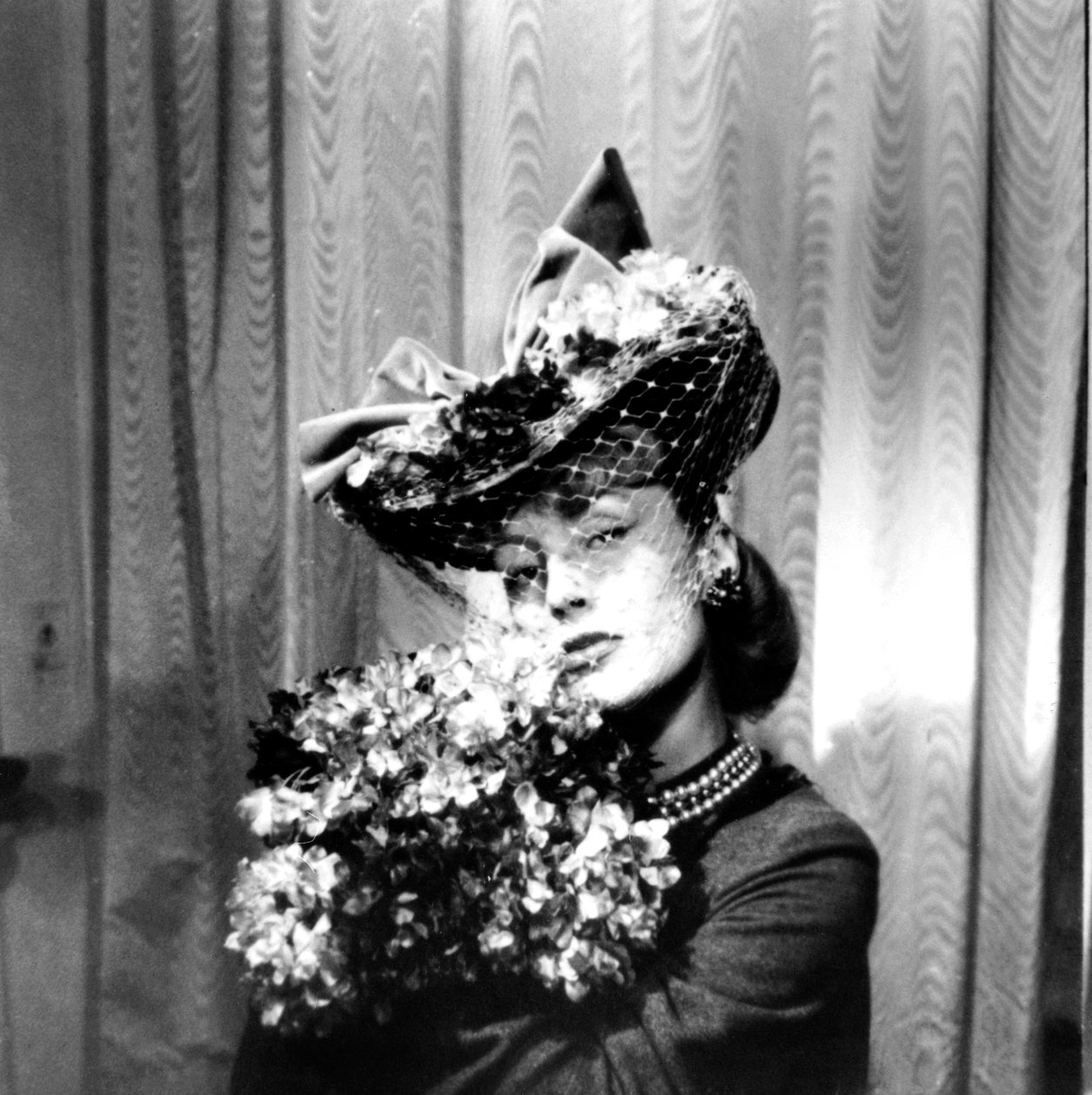 Femme portant un chapeau avec un voile, tenant un bouquet de fleurs, Paris, 1943 - Unbekannt