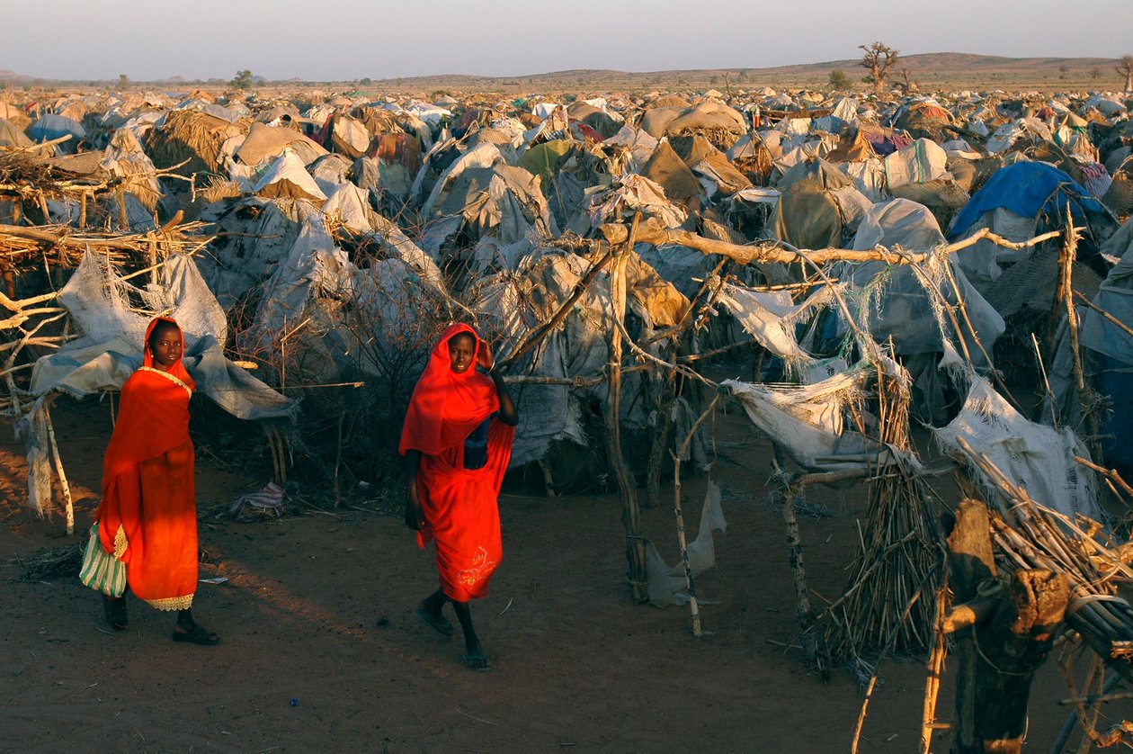 Habillées de vêtements rouges vifs, des femmes traversent le camp d