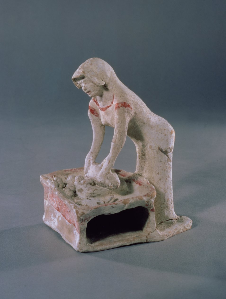 Femme pétrissant du pain sur une dalle carrée, grecque, d