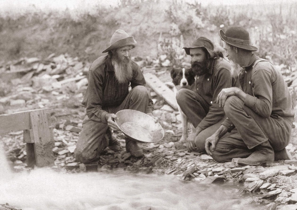 3 hommes filtrant la terre pour obtenir de l