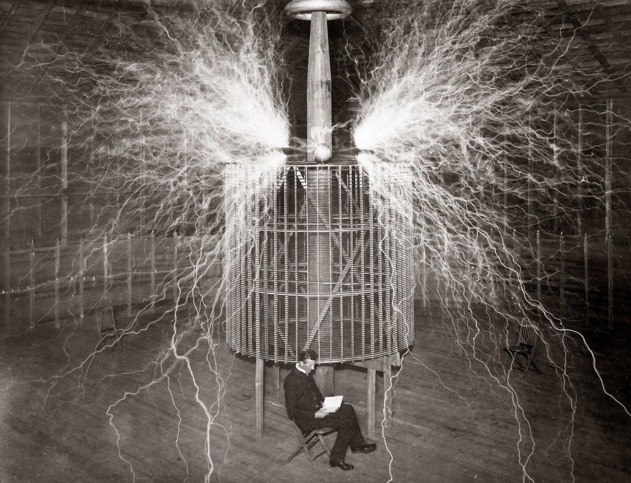 Nikola Tesla assis dans son laboratoire de Colorado Springs avec son « Transmetteur amplifiant » - Unknown photographer