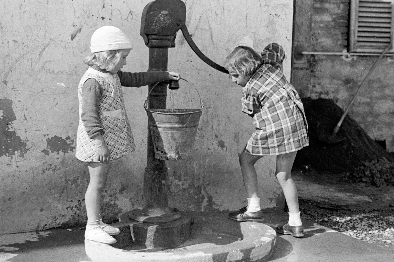 Petites filles remplissant un seau d