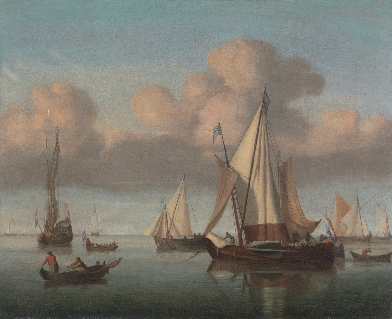 Un kaag au mouillage avec les voiles hissées et un yacht d