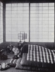 Fille endormie entre des couettes matelassées avec un oreiller en bois