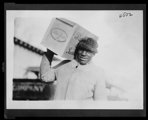 Homme afro-américain portant une caisse de whisky 