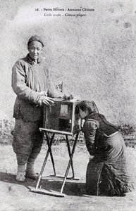 Petit métier : un amuseur ambulant avec une boîte à images Photographie du début du 20ème siècle - Collection privée