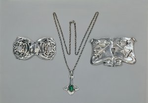 Bijoux en argent conçus pour Liberty. De gauche à droite : Fermoir de taille avec design celtique entrelacé, 1904. Pendentif et chaîne sertis de chrysoprase cabochon. Fermoir de taille avec design repoussé sur martelé - Archibald Knox