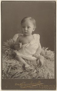 [Bébé non identifié assis sur un tapis en peau d