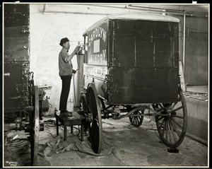 Un homme peignant au pistolet un wagon de livraison de Carolyn Laundry au 111 East 128th Street, East Harlem, New York, 1929 - Byron Company